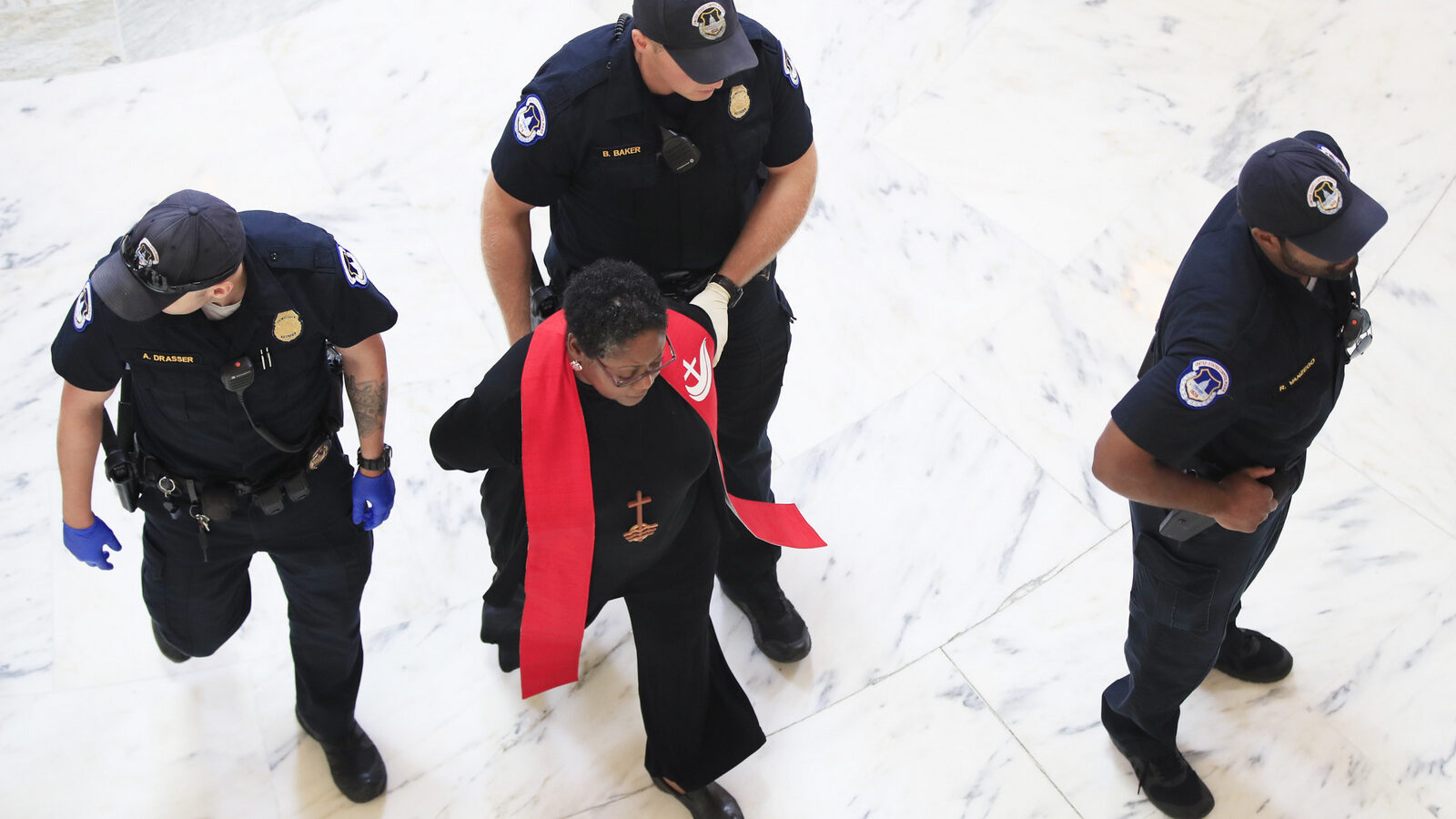 A minister belonging to a group protesting the Trump administration's budget proposals and health care bill, is arrested during in the Russell Senate Building on Capitol Hill in Washington, July 18, 2017. (AP/Manuel Balce Ceneta)