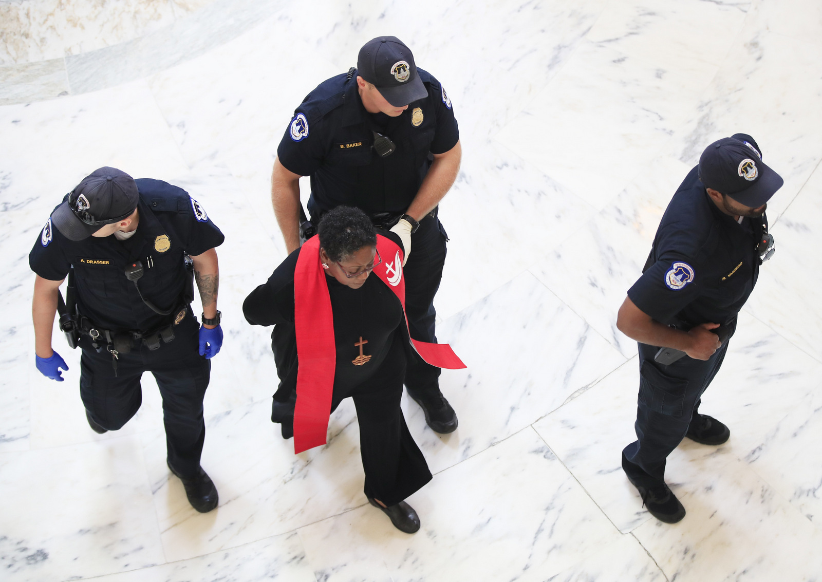 A minister belonging to a group protesting the Trump administration's budget proposals and health care bill, is arrested during in the Russell Senate Building on Capitol Hill in Washington, July 18, 2017. (AP/Manuel Balce Ceneta)