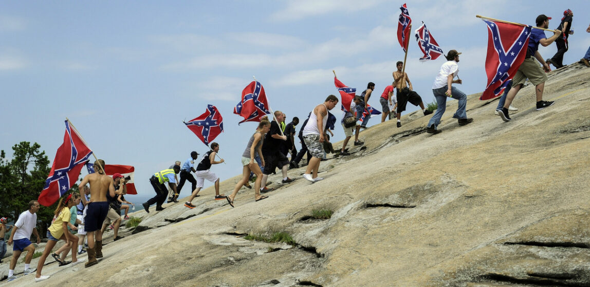 Confederate flag supporters climb Stone Mountain to protest of what they believe is an attack on their Southern heritage during a rally at Stone Mountain Park in Stone Mountain, Ga. Aug. 1, 2015. (AP/John Amis)