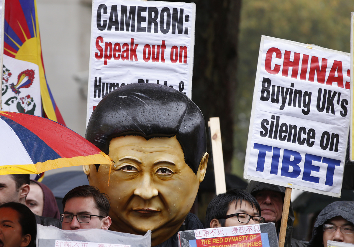 Supporters of the Falun Gong, with a supporter wearing a large head depicting the likeness of Chinese President Xi Jinping as they protest outside Downing Street as they wait for the arrival of Xi Jinping in London, Oct.  21, 2015. (AP/Alastair Grant )