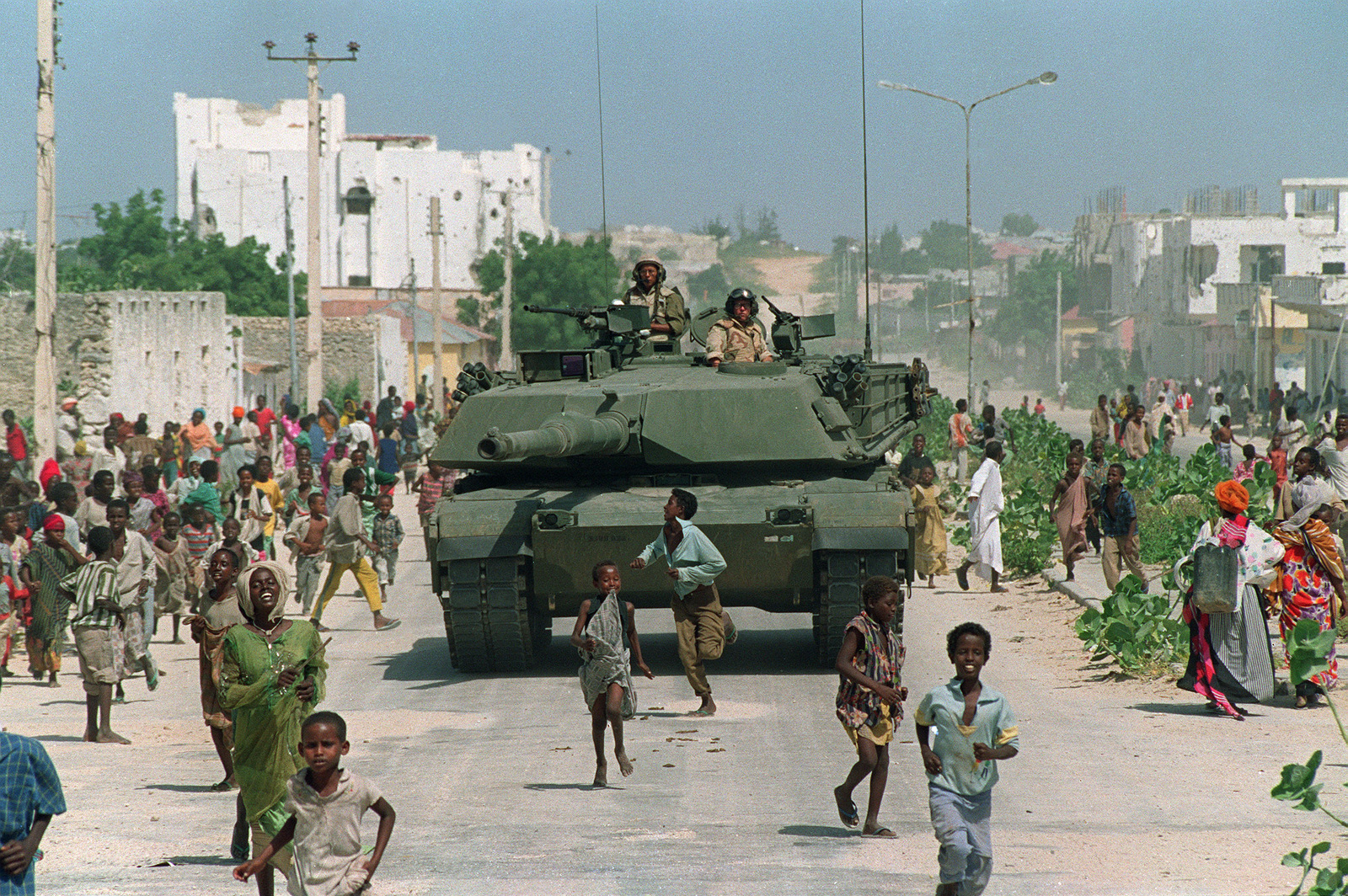 1993年1月26日，在索马里北部摩加迪沙的一次装甲巡逻期间，索马里儿童与美国海军陆战队M-1艾布拉姆斯坦克一起奔跑。（AP / Mark Duncan）