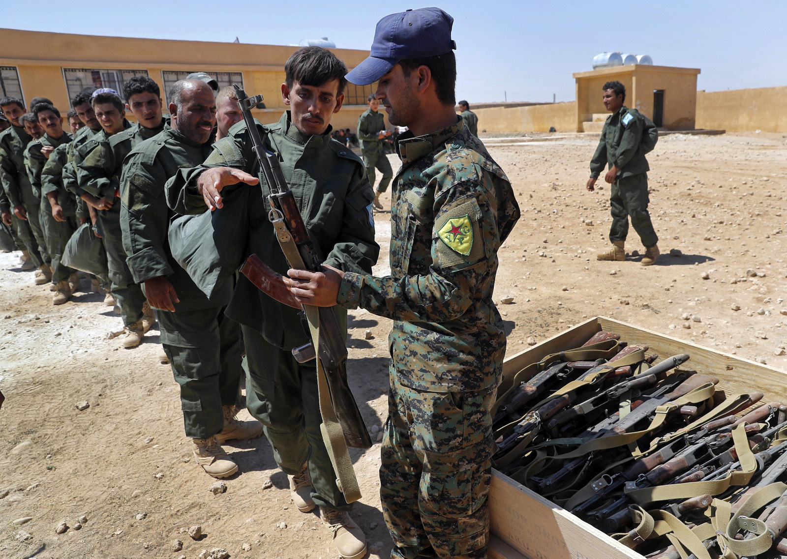  In this Thursday, July 20, 2017 file photo, Syrian Internal Security Forces receive weapons during their graduation ceremony, at Ain Issa desert base, in Raqqa province, northeast Syria. (AP/Hussein Malla)