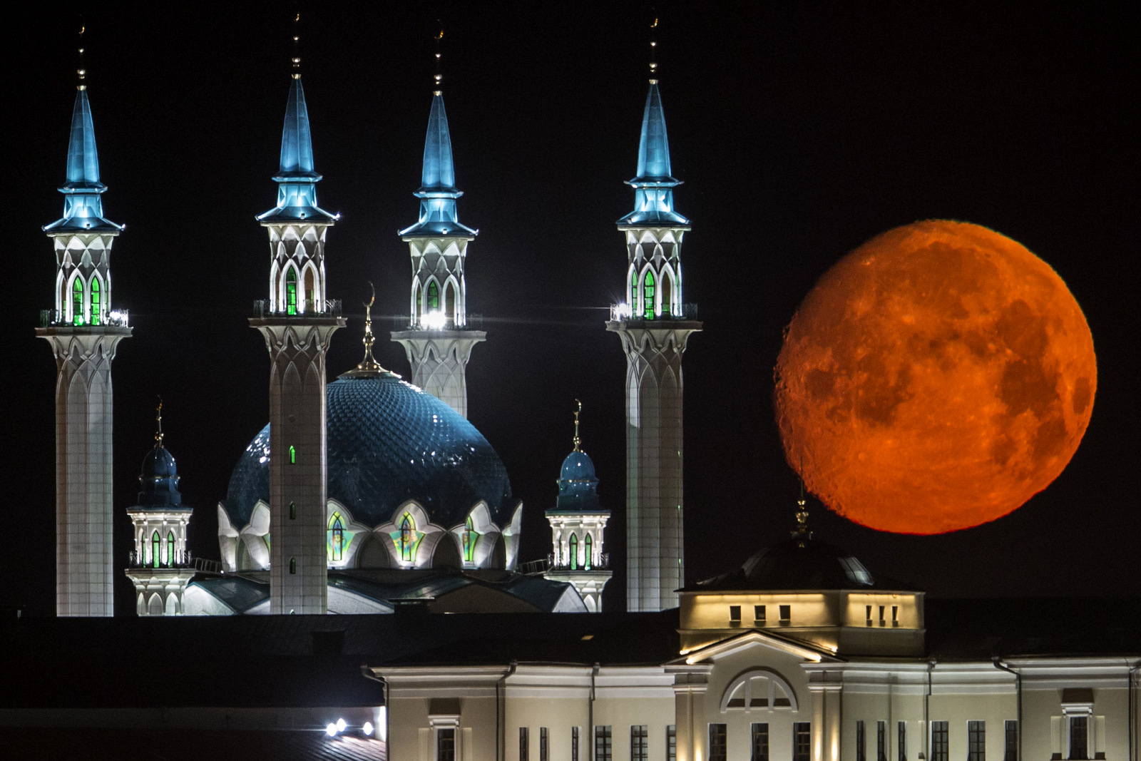 The full moon rises over the illuminated Kazan Kremlin with the Qol Sharif mosque illuminated in Kazan, the capital of Tatarstan, located in Russia's Volga River area about 700 km (450 miles) east of Moscow, July, 29, 2015. (AP Photo/Denis Tyrin)