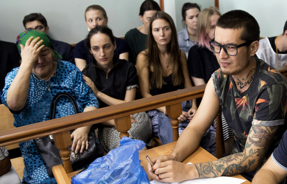Khudoberdy Nurmatov, who writes for Russian Novaya Gazeta newspaper under the pen name Ali Feruz, right, sits as his mother Zoya Nurmatova, left, gestures in a court room in Moscow, Russia, Aug. 8, 2017. A Moscow court has stopped the deportation of the reporter to his native Uzbekistan, in a gesture to a European court's order. (AP/Pavel Golovkin)