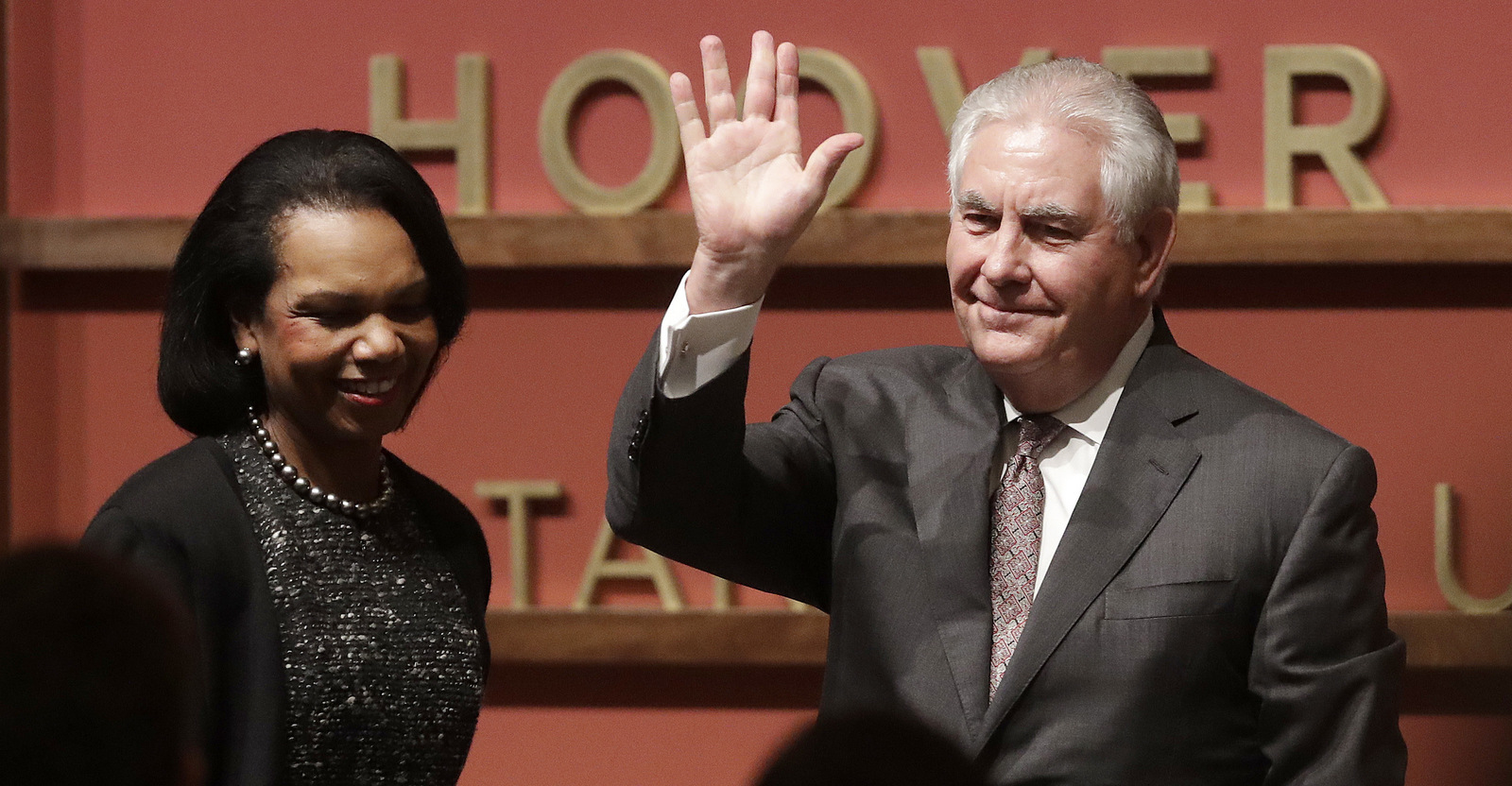 Secretary of State Rex Tillerson, right, waves after speaking to the Hoover Institution at Stanford University with former Secretary of State Condoleeza Rice, left, Jan. 17, 2018. Tillerson signaled the U.S. military will remain in Syria for the foreseeable future. (AP/Jeff Chiu)