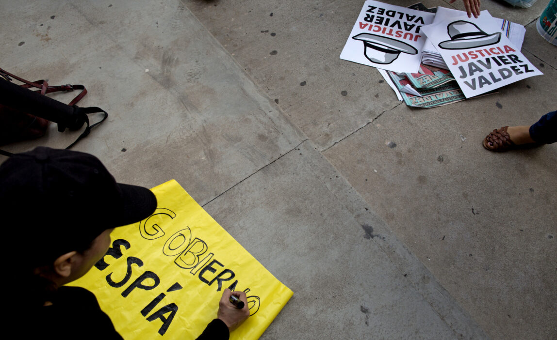 In this June 28, 2017 photo, a journalist makes a sign that reads in Spanish "Spy government" during a demonstration at the Sinaloa state attorney general's office against the killing of yet another journalist and demanding justice for the killing of Riodoce journalist Javier Valdez in Culiacan, Sinaloa state, Mexico. Recently it has been revealed that spyware sold exclusively to governments had been used to monitor journalists and activists in Mexico. (AP/Enric Marti)