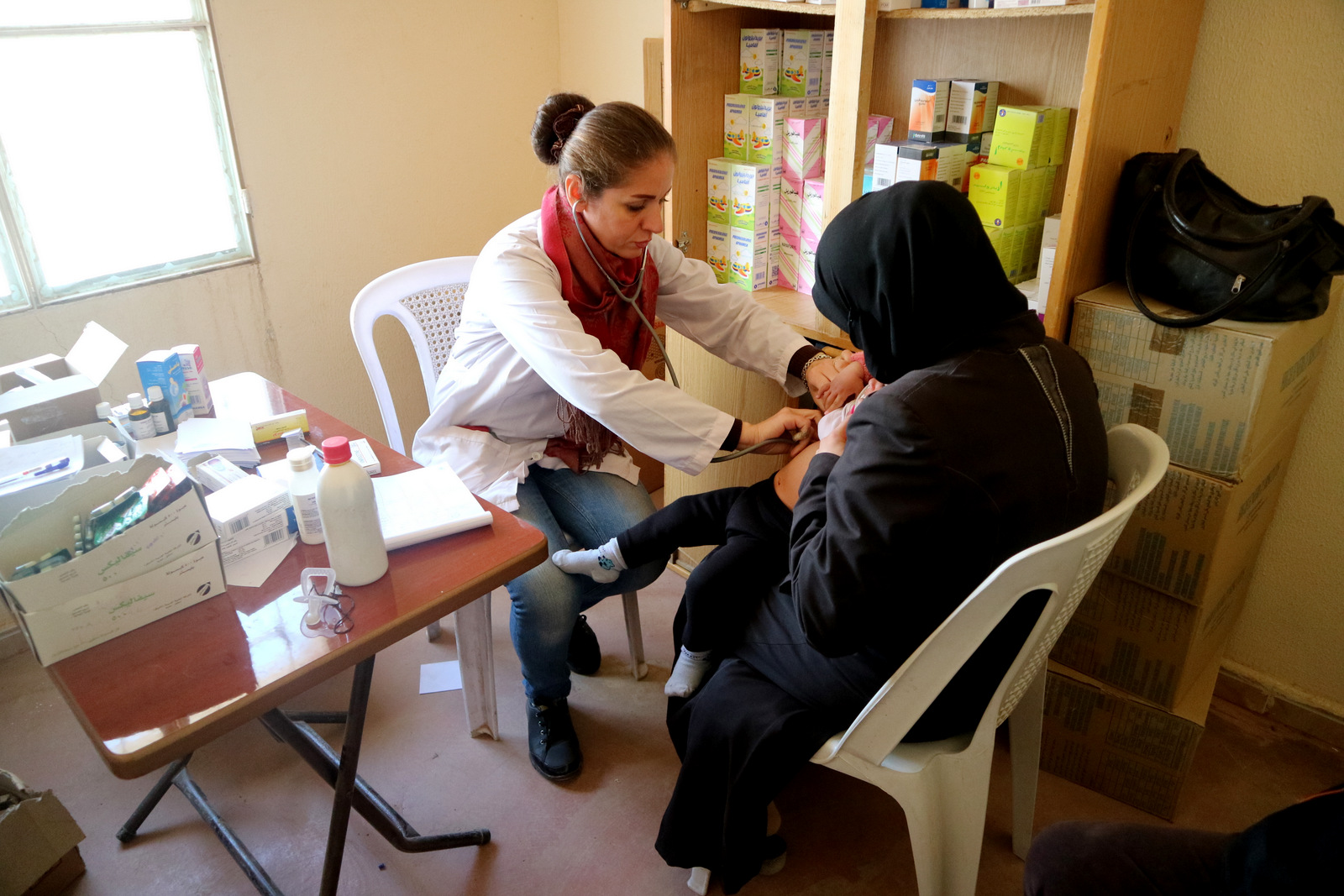 Dr. Jamilah al-Naemah treats a child sick with the flu at a medical center in al-Harjallah, Eastern Ghouta. (Photo: © Bas Spliet)