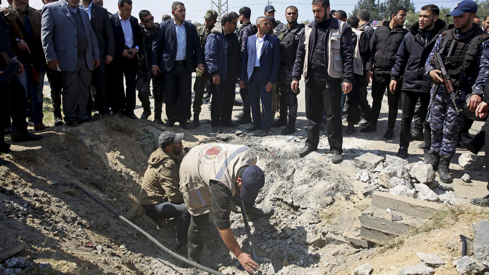 Security services inspect the site of an explosion that occurred as the convoy of Palestinian Prime Minister Rami Hamdallah entered Gaza from with Israel, on the main road in Beit Hanoun, Gaza Strip, March 13, 2018. (AP/Adel Hana)