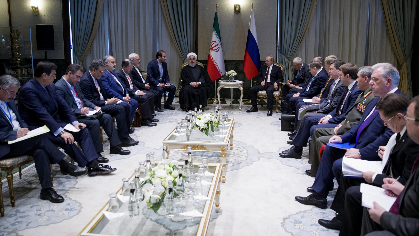 Iran's President Hassan Rouhani, center left, and Russia's President Vladimir Putin, centre right, flanked by their delegations as they speak during a meeting in Ankara, Turkey, Wednesday, April 4, 2018. The leaders of Russia, Iran and Turkey are meeting in the Turkish capital for talks on Syria's future. The leaders are expected to reaffirm their commitment to Syria's territorial integrity and the continuation of local cease-fires when they meet Wednesday. (Tolga Bozoglu/Pool Photo via AP)