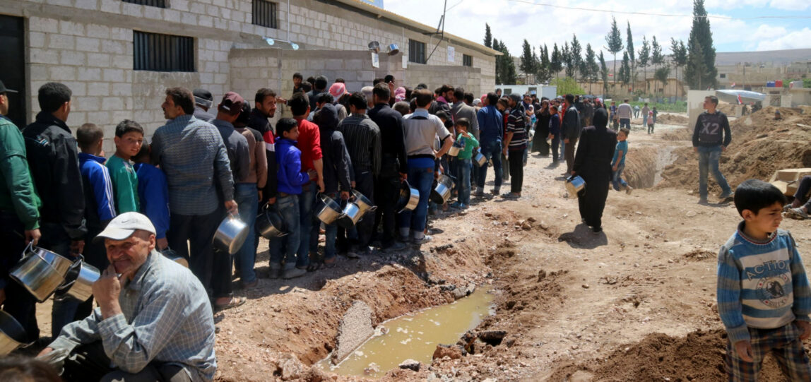 Civilians from Eastern Ghouta wait in line to receive free food from the al-Harjallah centre. (Photo: © Bas Spliet)