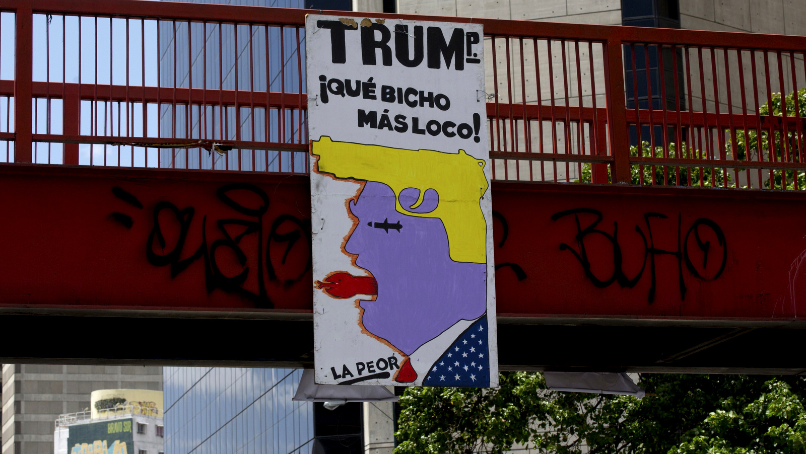 A sign with an image representing U.S. President Donald Trump and a text that reads in Spanish "Trump, what a crazy critter!" hangs from a bridge in Caracas, Venezuela, March 8, 2018. Fernando Llano | AP
