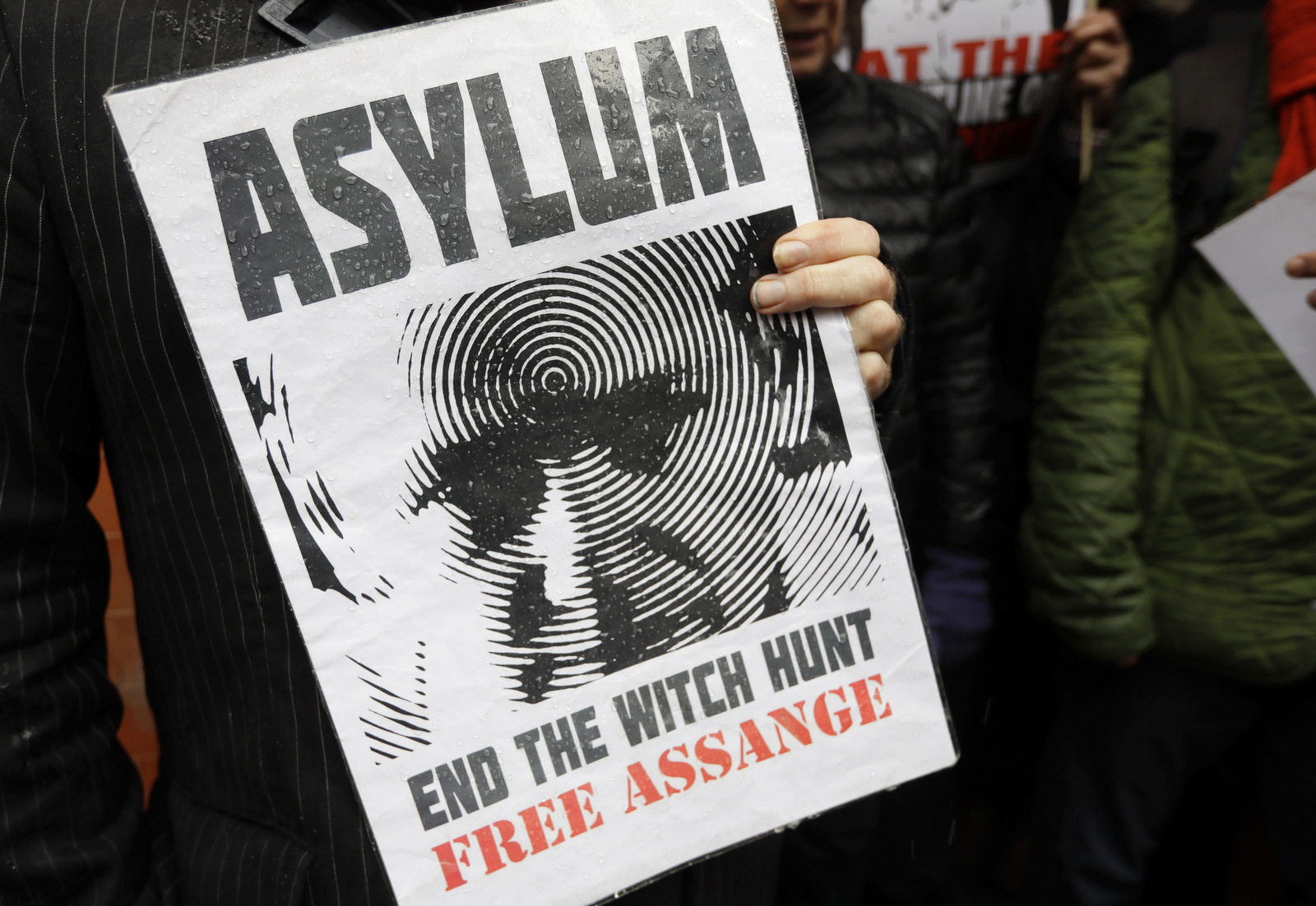 A supporter of Julian Assange holds a banner during a protest outside the Ecuadorian embassy in London, March 29, 2018. Kirsty Wigglesworth | AP