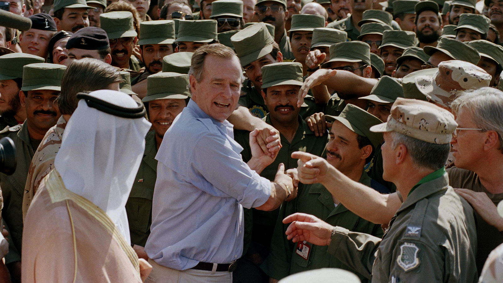 President George Bush is greeted by Saudi troops and others as he arrives in Dhahran, Saudi Arabia, for a Thanksgiving visit, Nov. 22, 1990. J. Scott Applewhite | AP