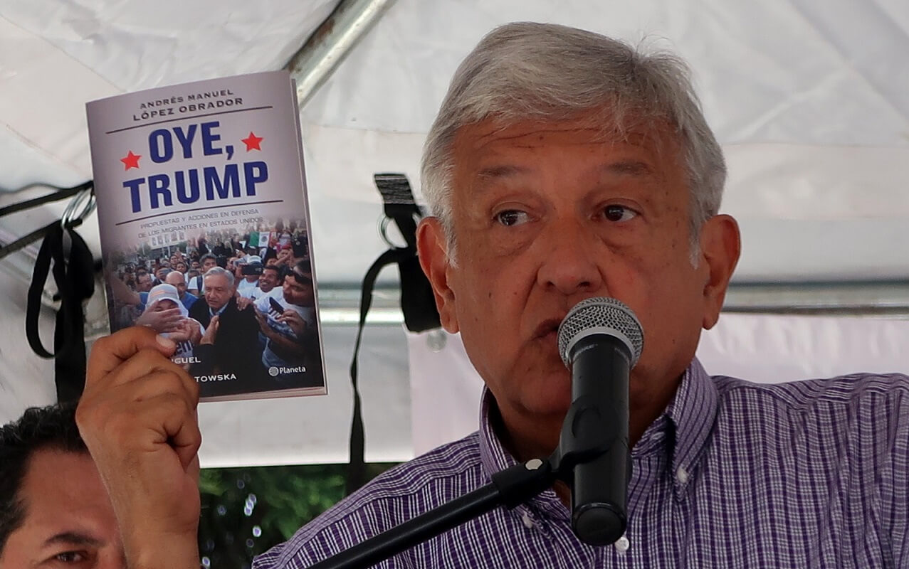 Andrés Manuel López Obrador holds a copy of his Oye, Trump .Pagina Bierta