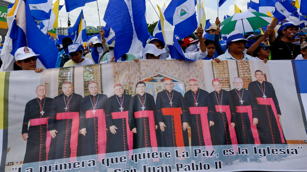 Anti-government protesters hold a banner featuring clerics at a march supporting the Catholic church, in Managua, Nicaragua, July 28, 2018. Alfredo Zuniga | AP