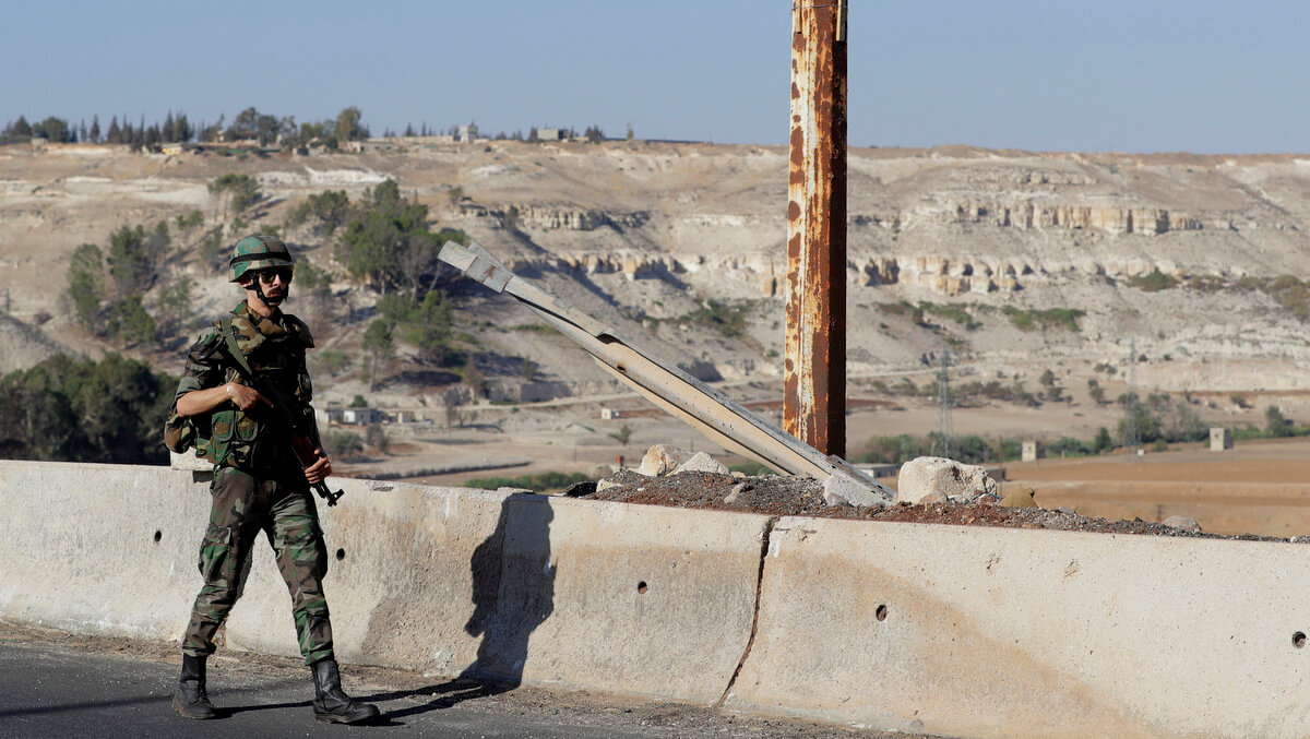 A Syrian army soldier patrols a bridge in the town of Rastan, Syria, Aug. 15, 2018. Russia said it is coordinating efforts to help Syrian refugees return home and rebuild the country's infrastructure. Sergei Grits | AP