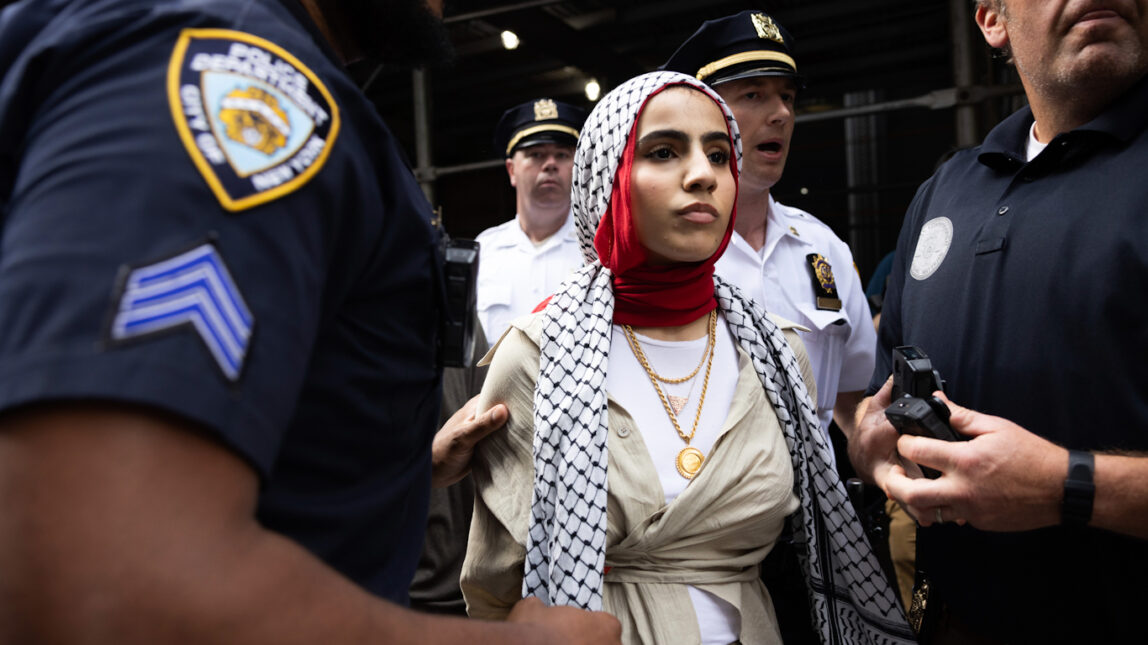 NYPD officers arrest a woman as pro-Palestine and pro-Israel protesters clash outside Baruch College in New York, June 5, 2024. Melissa Bender | AP