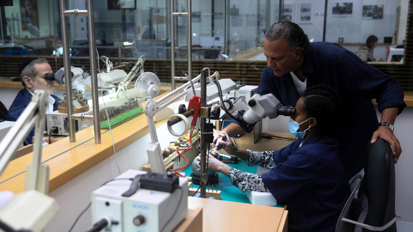 Isaac Levy, owner of Yvel, watches over a worker assembling a diamond-encrusted COVID-19 face mask at the company’s workshop in Jerusalem, Aug. 9, 2020. Photo | AP