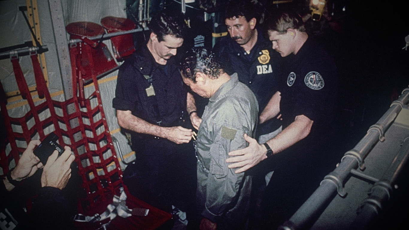 Manuel Antonio Noriega watches as U.S. Drug Enforcement Agents place chains around his waist aboard a C-130 transport plane on Jan. 4, 1990. Noriega surrendered to U.S. authorities in Panama City and was flown to Miami, Florida, where he faced drug trafficking charges. Photo | AP